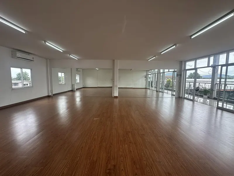The full studio floor with mirrored wall and balcony doors
